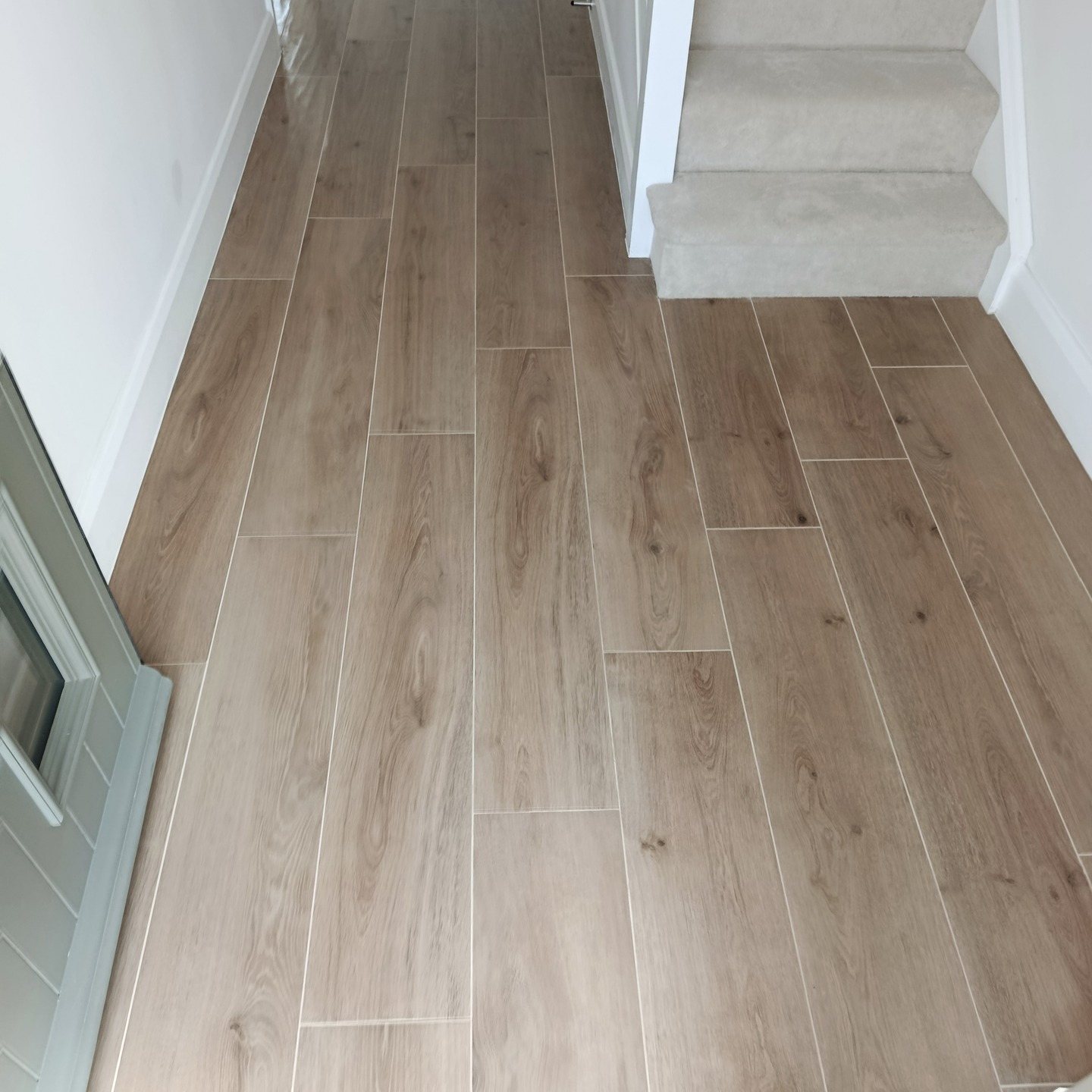 Finished wood-effect tiled floor in a bright kitchen and living space