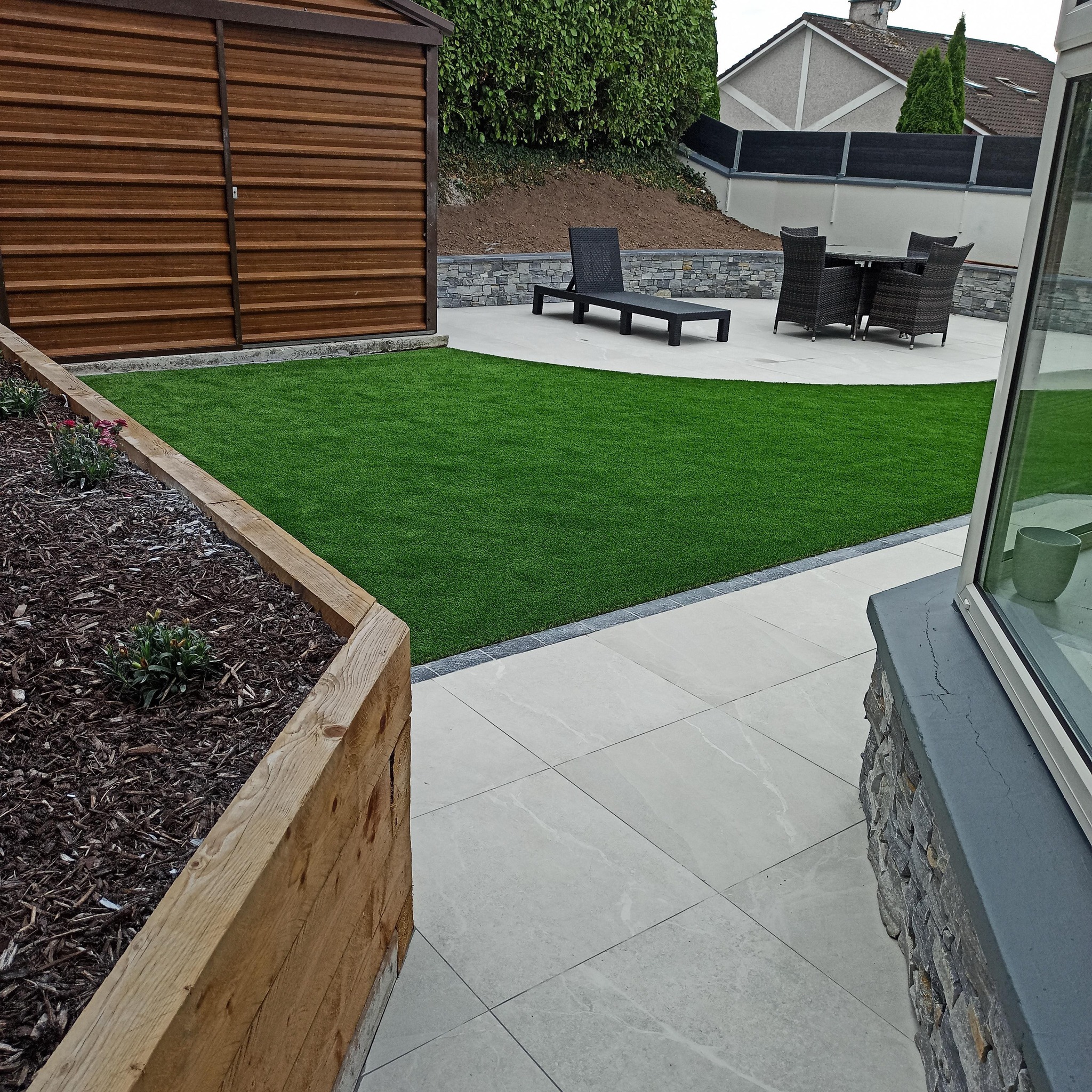Landscaped garden with artificial grass, patio paving and raised flowerbed