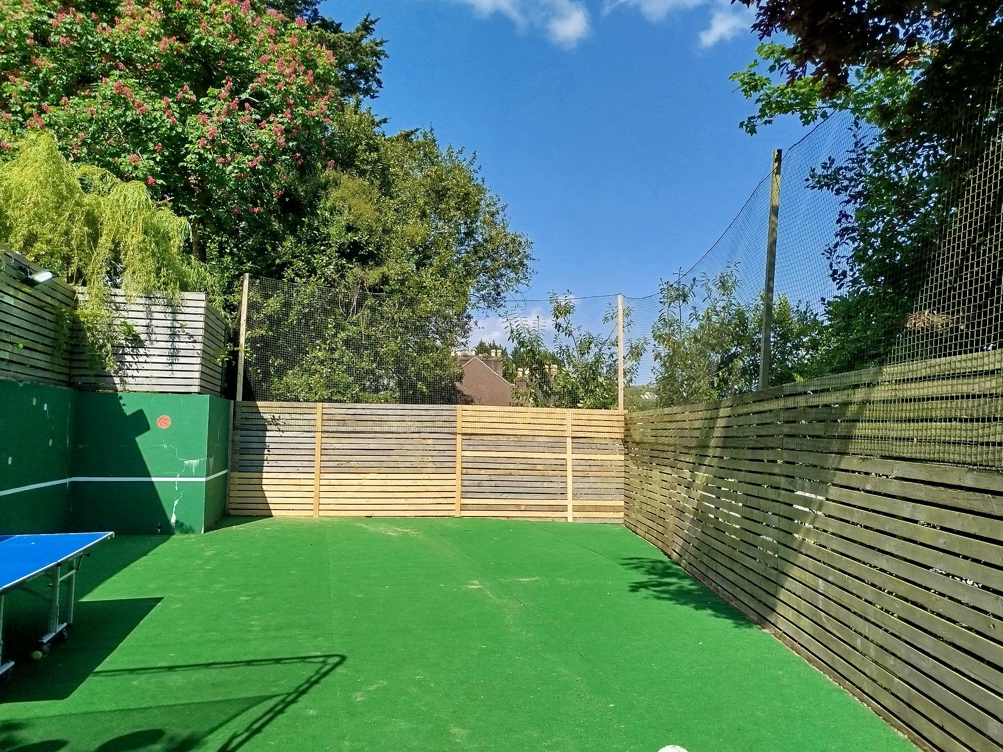 Outdoor fenced area with timber fencing and protective netting